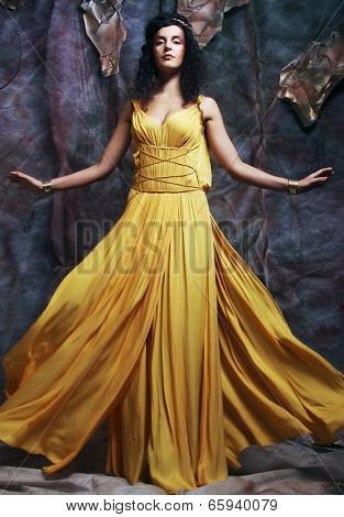 beautiful young brunette woman wearing yellow evening dress