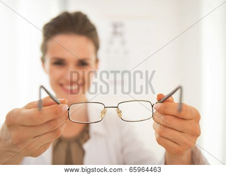 Closeup On Ophthalmologist Doctor Woman Giving Eyeglasses