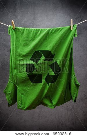 Green T Shirt With Recycle Symbol Hanging On Rope To Dry