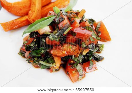 vegetable salad : cherry tomatoes and basil with sweet baked potato served on white plate with sauceboat full blask soy sauce on wood