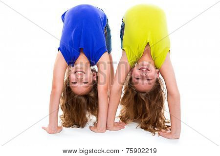 twin kid sisters playing as flexible contortionist happy on white background