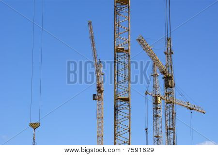 เครนก่อสร้าง elevating กับฟ้าในสภาพอากาศที่เหมาะสม