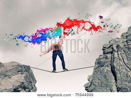 Young guy in casual evading from colorful paint splashes
