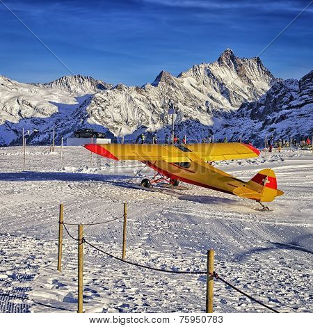 Yellow Red Airplane At The Mountain Ski Resort Airfield In Swiss Alps