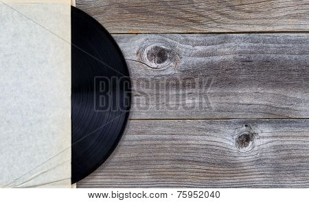Original Vinyl Music Record In Paper Holder On Aged Wood