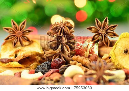 christmas spices, nuts, cookies and dried fruits on bokeh background