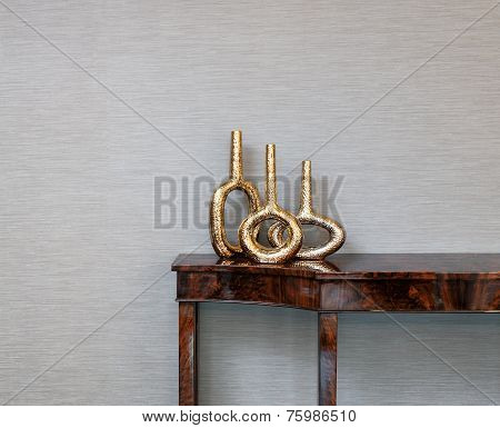 Sideboard In Front Of A Grey Wall And Art Objects