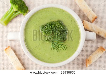 Portion of green broccoli cream soup restaraunt recipe in a white bowl