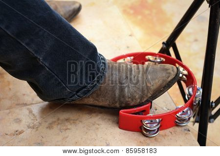 Musician Are Using A Foot Knocked Tambourine