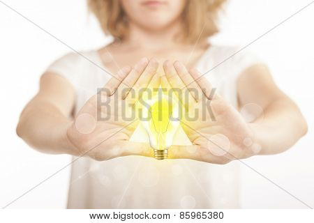 Hands creating a form with yellow light bulb in the center