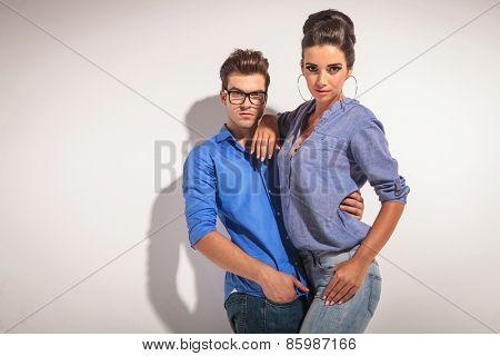 Gorgeous fashion woman posing with her lover on greu studio background.