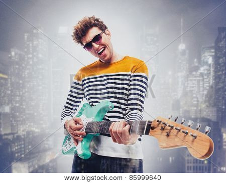 Double exposure of a city and happy man playing guitar