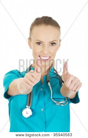 Beautiful smiling woman doctor with thumbs up.