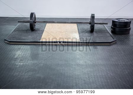 A barbell next to weights in crossfit gym