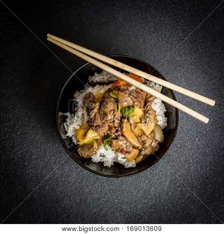 Asian rice with beef meat and vegetagles on dark background