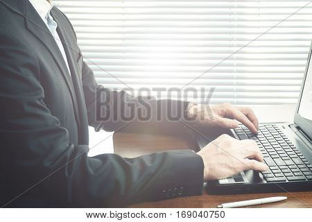 Business man working at office with laptop on his desk