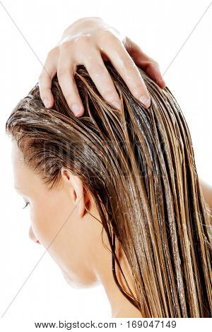 Photo of woman applying hair conditioner.