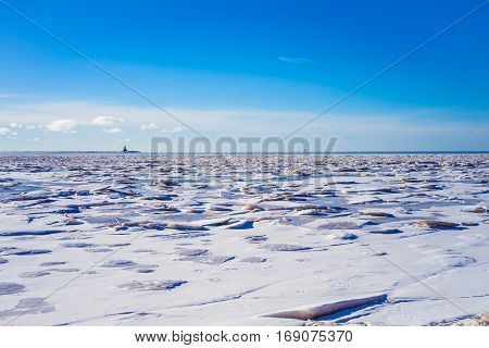 Ice of the shore along the Atlantic coast of Prince Edward Island, Canada.  Indian Head Lighthouse at the horizon.