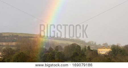 Mansion House of Bailbrook House Hotel and Solsbury Hill, with rainbow. Grade II listed building on the outskirts of the UNESCO World Heritage city of Bath in Somerset UK