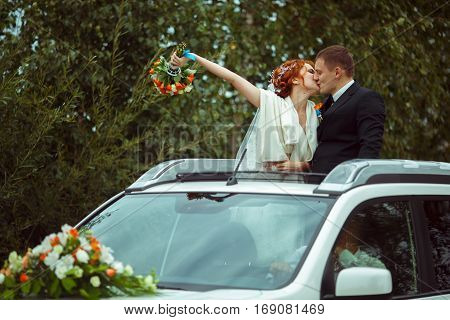 Just Married Kiss Standing In The Hatchway Of A Car