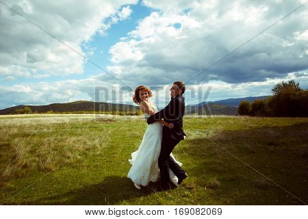 Happy Wedding Couple Dance On The Hill Under A Deep Blye Sky