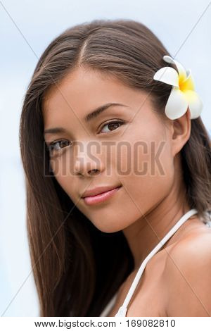 Asian beauty young woman hawaiian flower portrait. Wellness skincare treatment concept. Serene multicultural girl outdoors at tropical spa. Young mixed race model on Hawaii.