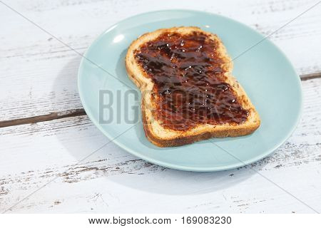 Typical Dutch apple syrup called Appelstroop on bread on wooden background
