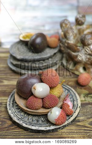 Tropical fruits - Lychees and Passion Fruit or Maracuya on wooden background