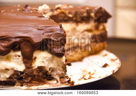 Sliced layered chocolate cake with chocolate icing on a plate