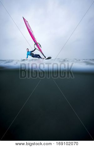 frontview windsurfer in an over underwater shot