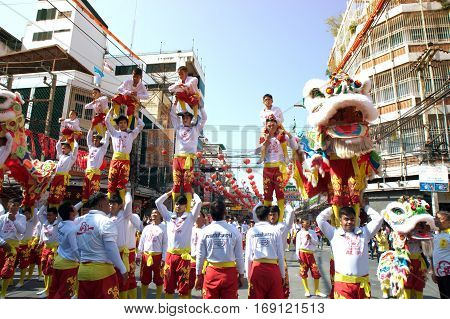 NAKHONSAWAN ,THAILAND - JANUARY 31,2017 : Unidentified people dancing with Chinese Lion of Gods doing ritual at worship altar table during the Chinese New Year celebrations in Nakhonsawan Province , Middle of Thailand.