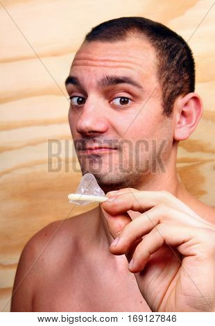 Young Handsome Boy Shows And Keeps A Condom