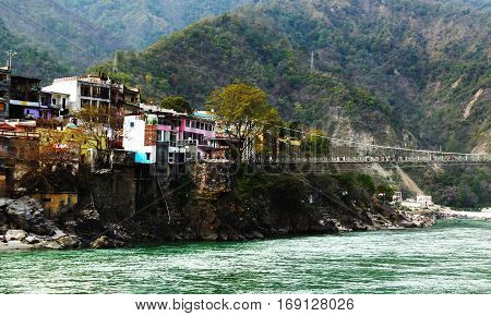 View to Ganga river, colored houses and lakshman jhula bridge, Rishikesh, India