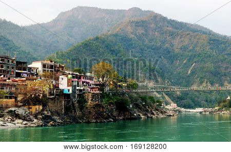 View to Ganga river, colored houses and lakshman jhula bridge, Rishikesh, India