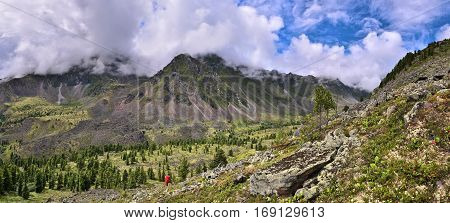 Panoramic view of mountain valley from slope. Siberian woodlands and alpine tundra. Eastern Sayan. Siberia. Russia