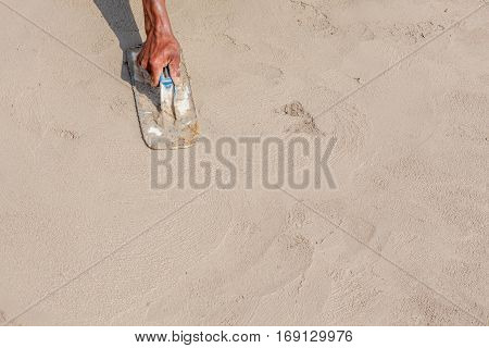 Moving hand and shadow of mason worker using steel trowel plastering aligns with cement floor under construction concept.