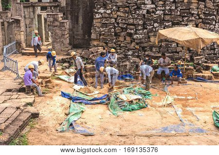 Bayon, Siem Reap, Cambodia - December 7, 2016: Architects And Workers