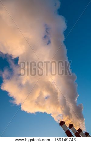 environmental pollution concept, pipes and smog on blue sky background