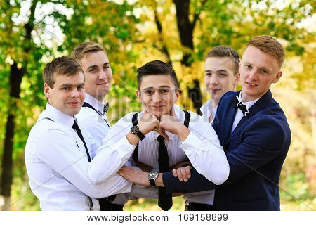 True men friendship. Group of handsome stylish men enjoying time together on wedding of their friend. Smiling happy cheerful men spend time together outdoors in spring, summer. Old friends.
