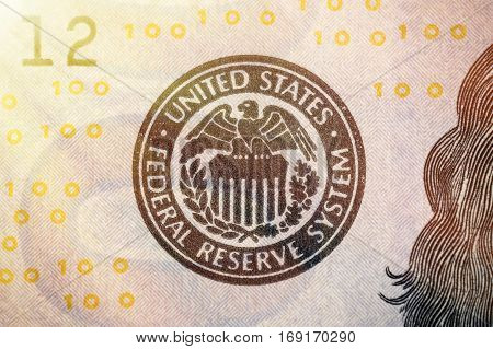 United States Federal Reserve System symbol from hundred dollar bank note. Close up shot with sun beams effect.