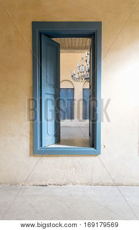 Blue wooden opened window of a old historic building with vintage plaster wall Medieval Cairo Egypt