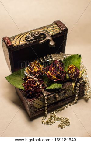 Wonderful trunk with dry roses and brilliant necklace.