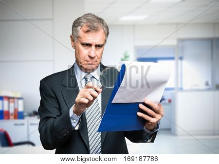 Businessman analyzing a document in his office