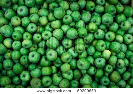 background of bright green apples on sale at the local market