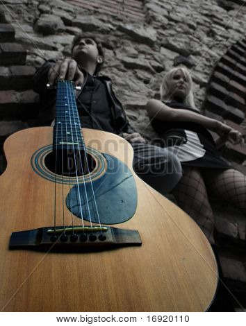 schönes blondes Mädchen und jungen mit Gitarre