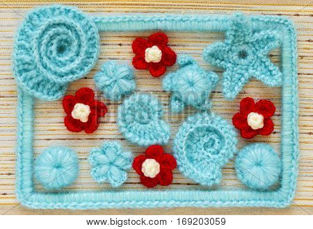 Marine background with cotton lace crochet craft elements: stars shells flowers and frame made of soft acrylic like wool yarn. Crocheted creative small doilies. Decorative needlework marine design