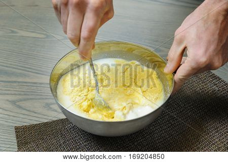 Preparation baking the pie. Hands cook stir dough in a metal bowl.