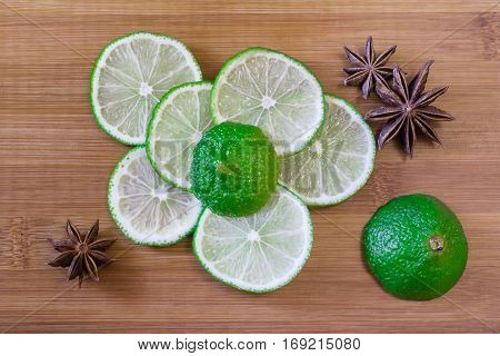 Green lime slices with star anise on a bamboo board