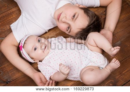 Brother hugging his newborn sister. View from above.