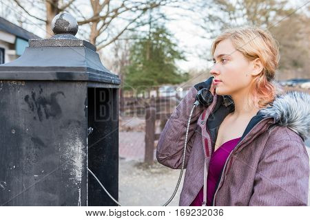 Young woman calling in phonebooth in winter